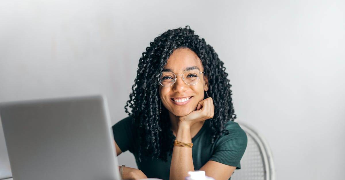 Happy Ethnic Woman Sitting At Table With Laptop