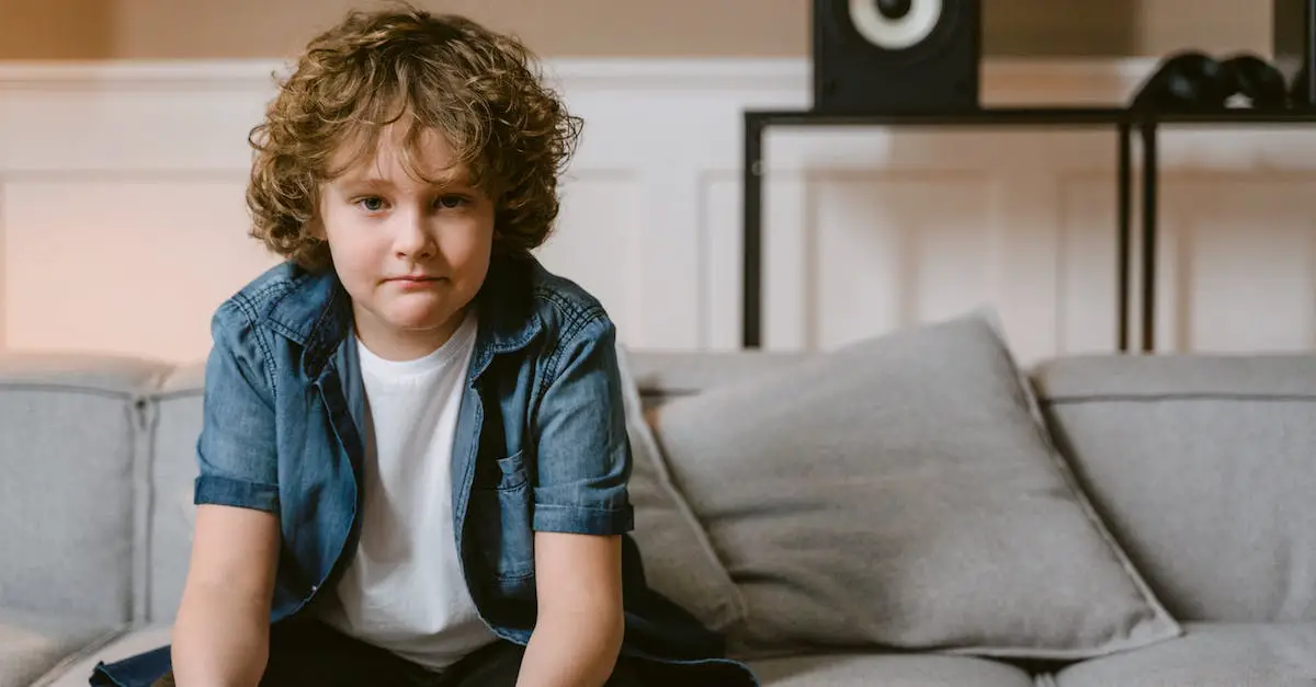 Boy Sitting On Couch Holding A Game Controller